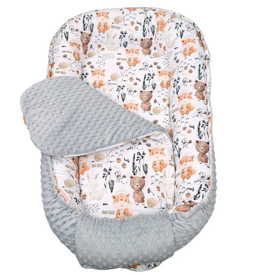 Baby bouncer nest with teddy bear woodland animals and floral pattern on a white background