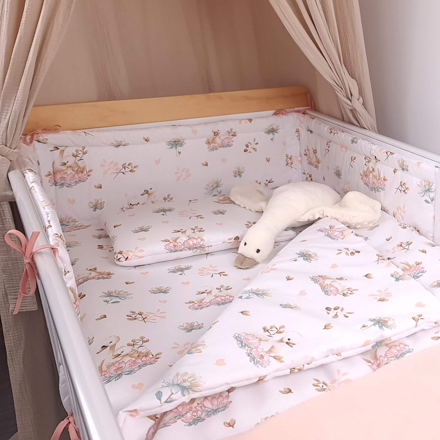 Baby girl nursery bedding set with swan and lotus flower pattern including cot bumper, blanket, and fitted sheet