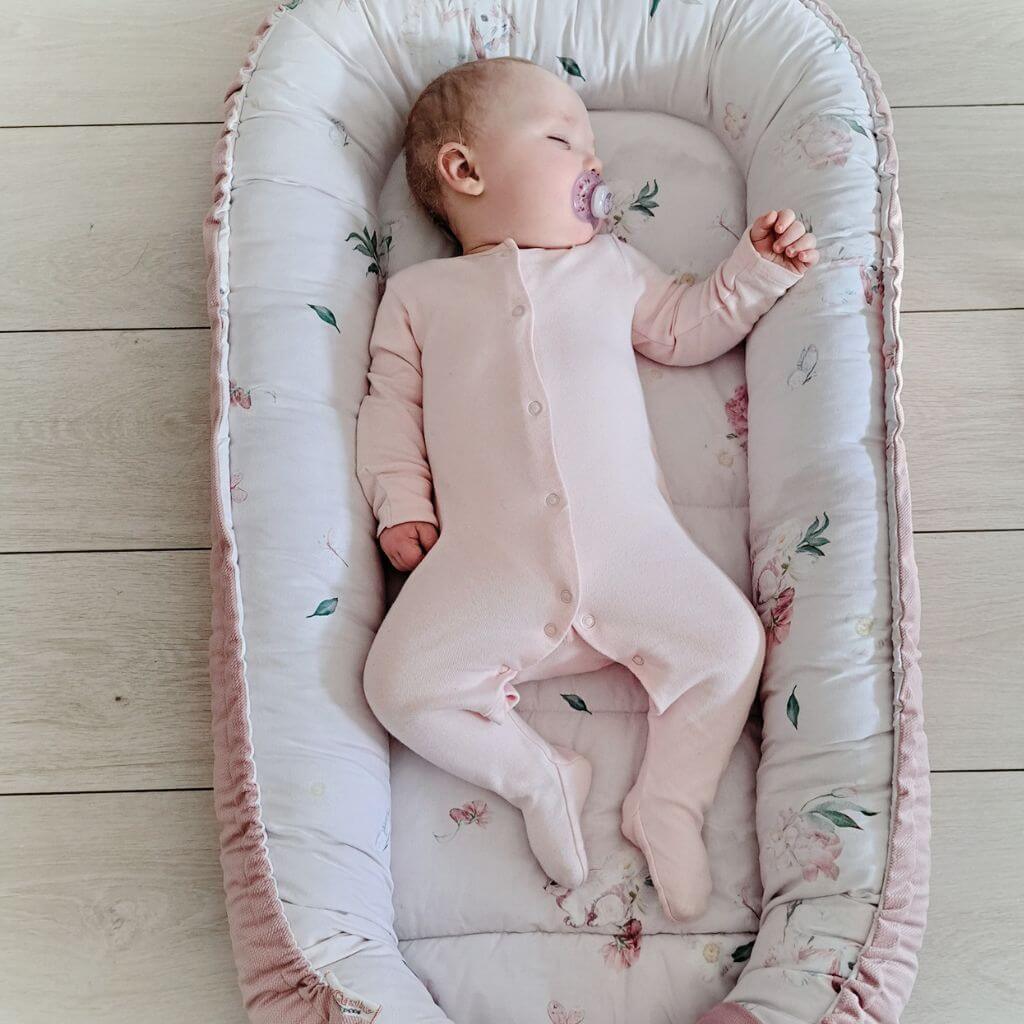 big handmade pink bunny pattern cotton nest on the floor with baby sleeping