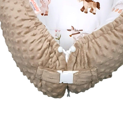Close-up of Farm Friends pattern with ponies, cows, piglets, chicks, sheep, and bunnies on white cotton toddler sleep pod nest

