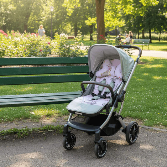 Stroller with a child in a park setting with a pink insert and pillow