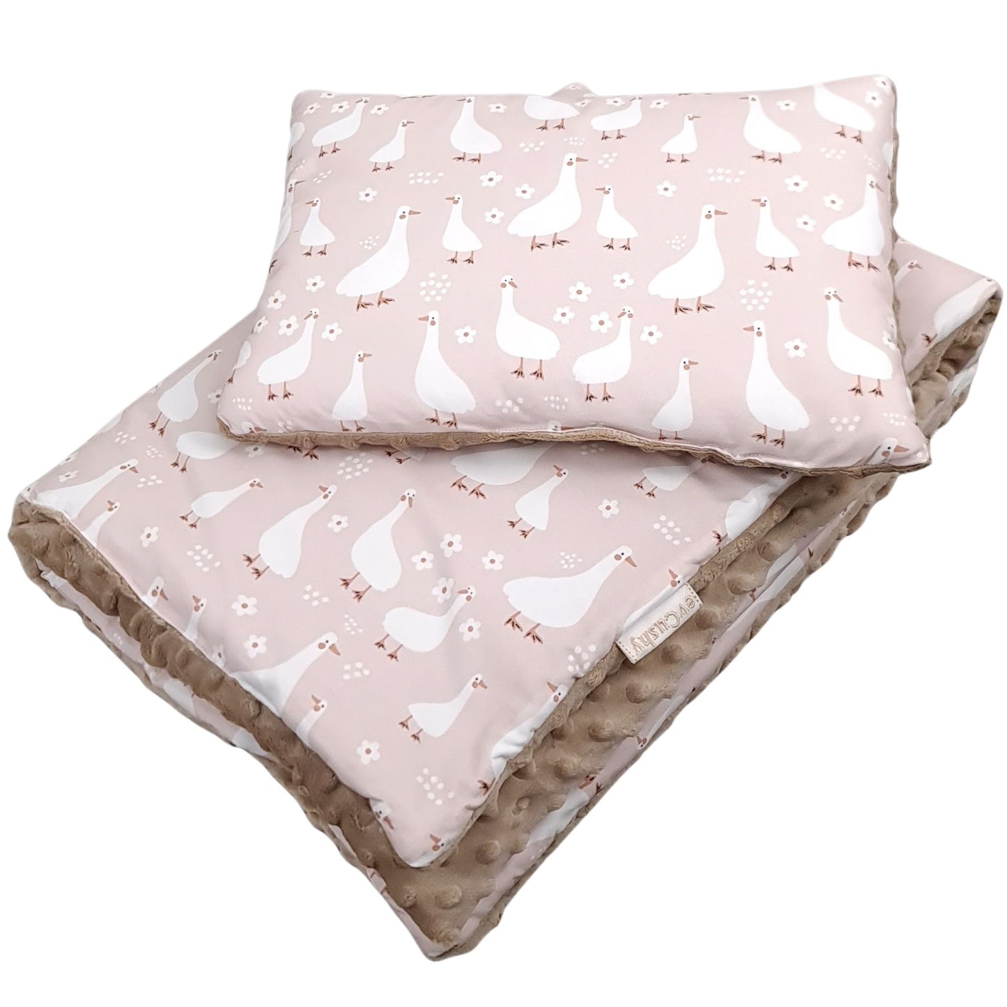 Close-up of nursery bedding set featuring delicate white geese pattern on soft pink cotton background