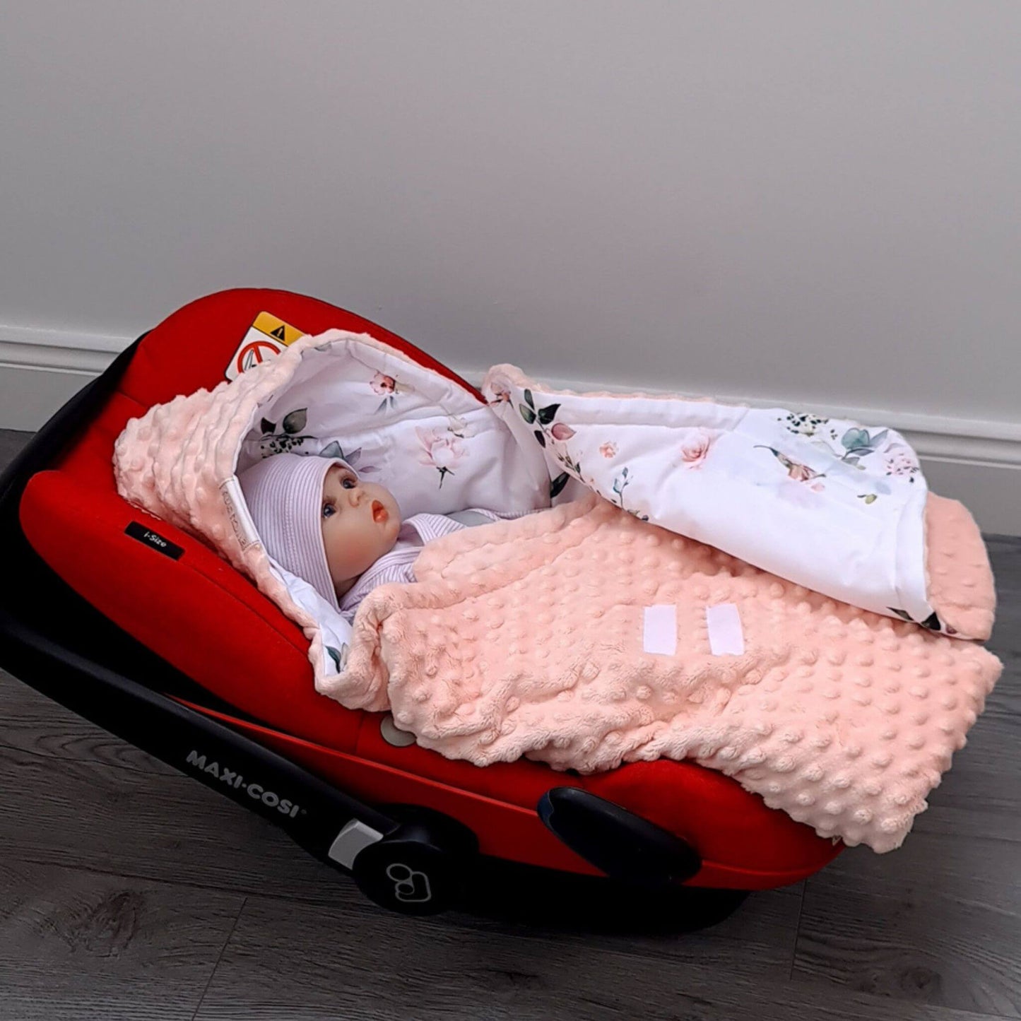 Baby wrapped in hummingbirds floral car seat blanket with hood with velcro closing.