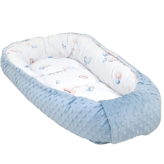 A baby Moses basket bassinet with a light blue textured dotty blanket border and a white patterned interior, shown on a solid white background.