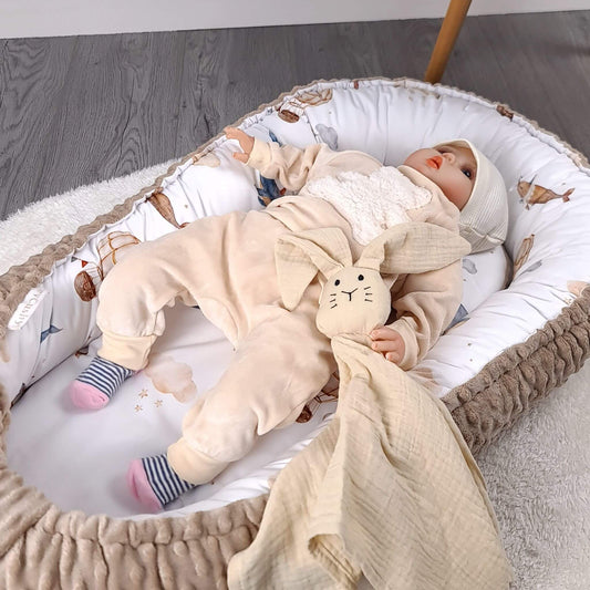 Baby relaxing in Evcushy Baby Nest Deluxe with whales and hot air balloons