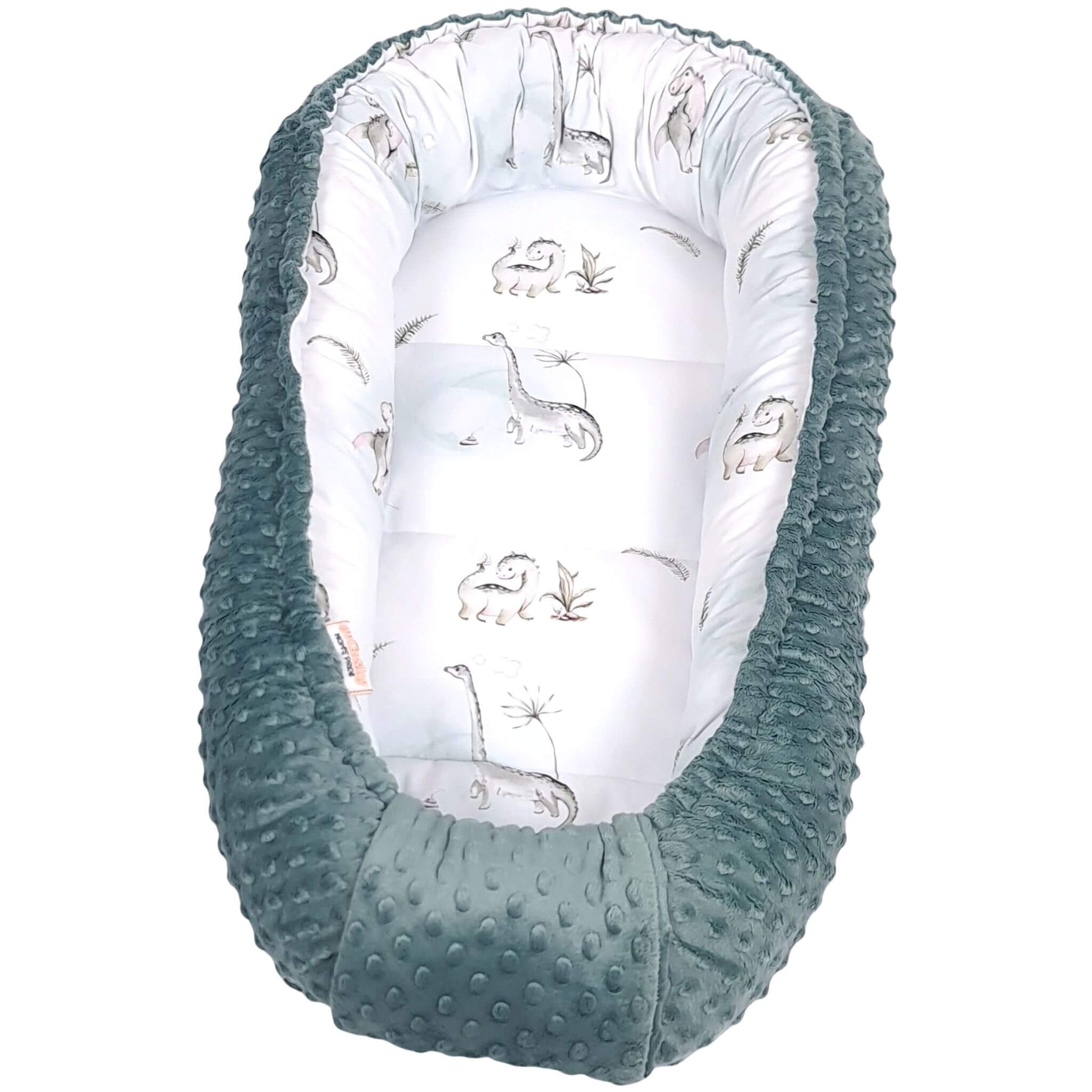Baby nest with sage green exterior and white interior featuring dinosaur prints on a white background