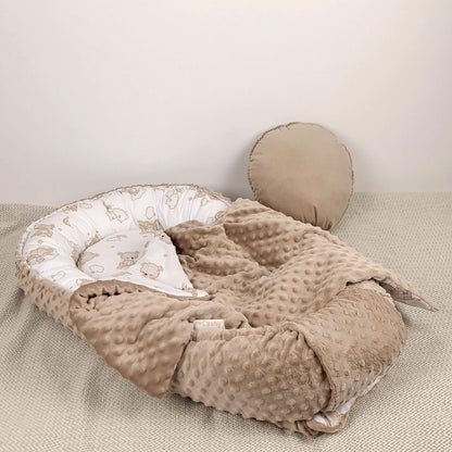 Close-up of the teddy bear cotton print and textured taupe dimple minky fabric on the Evcushy baby nest