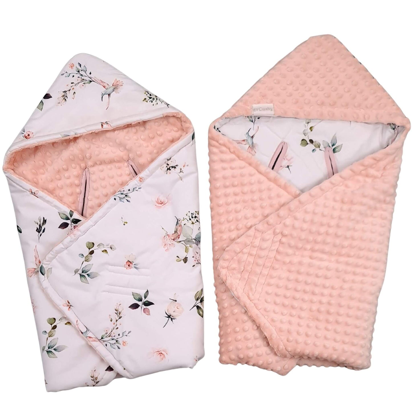 Two folded baby blankets with hoodies shown side by side on a white background. One blanket has a white floral print with a peach-pink minky texture hood and lining, and the other shows the peach-pink waffle-textured reverse side.