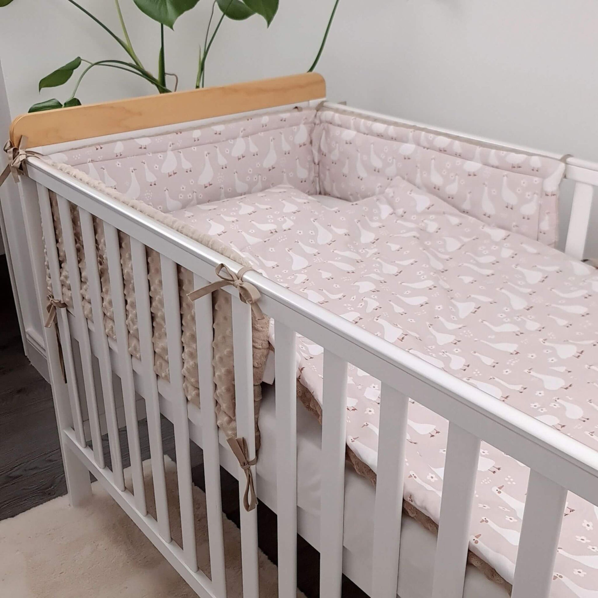 Evcushy Geese Family cot bed bumpers made from premium cotton and ultra-soft minky plush, displayed inside a baby's cot.