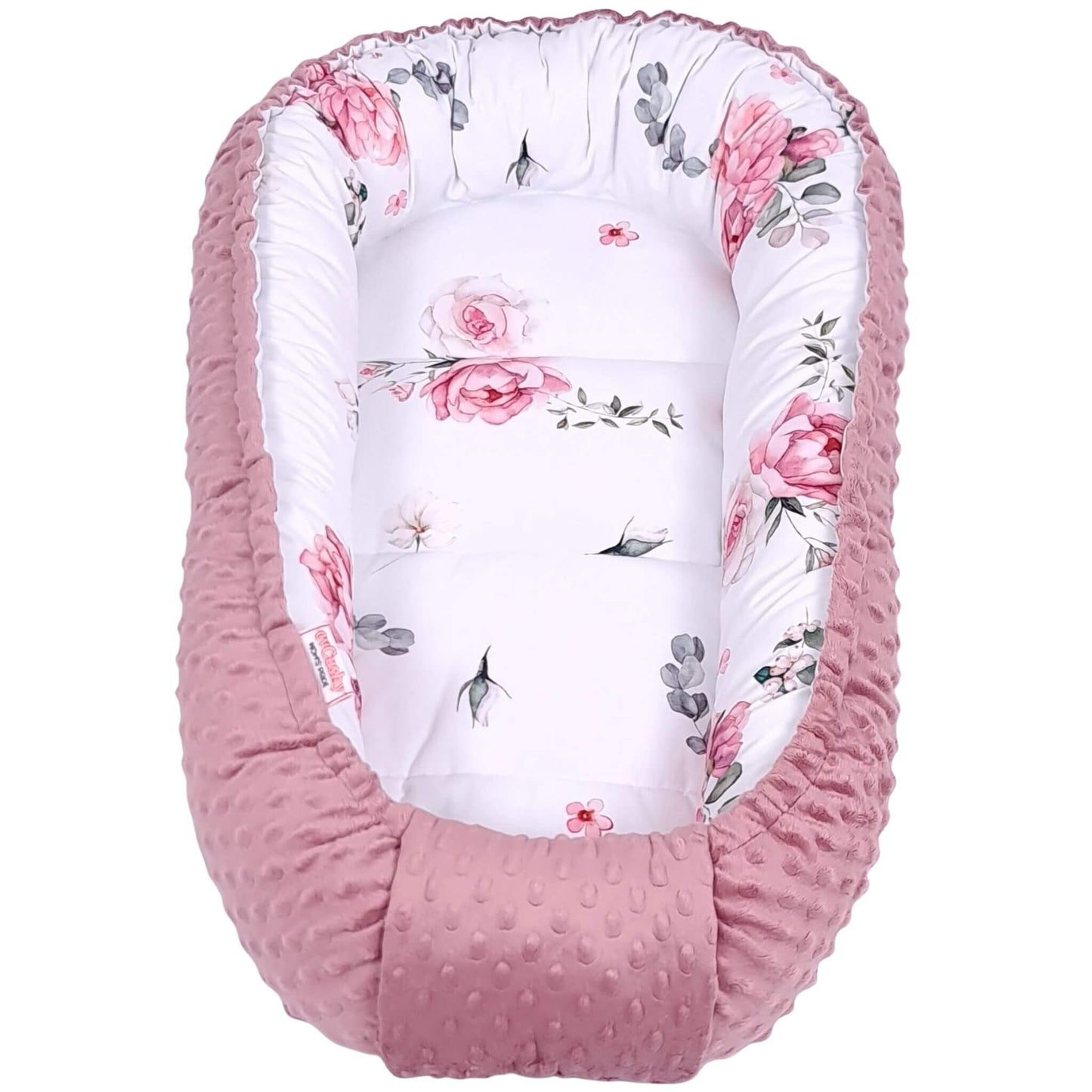 Floral-patterned baby nest with pink exterior and beautiful floral roses pattern handmade in Ireland