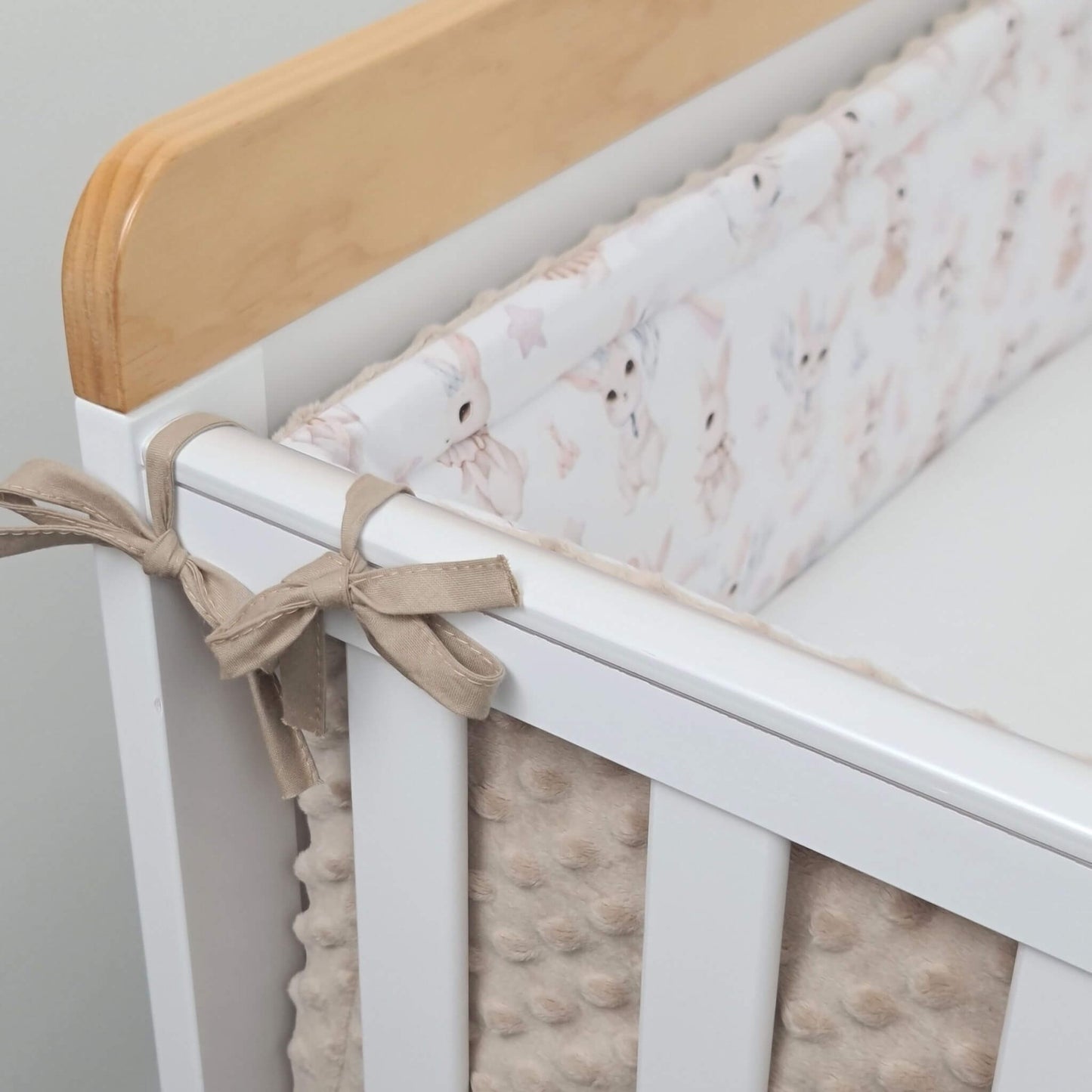 Close-up of retro bunny cotton fabric and ribbon bow details on cot bumper in standard cot bed 40x70cm