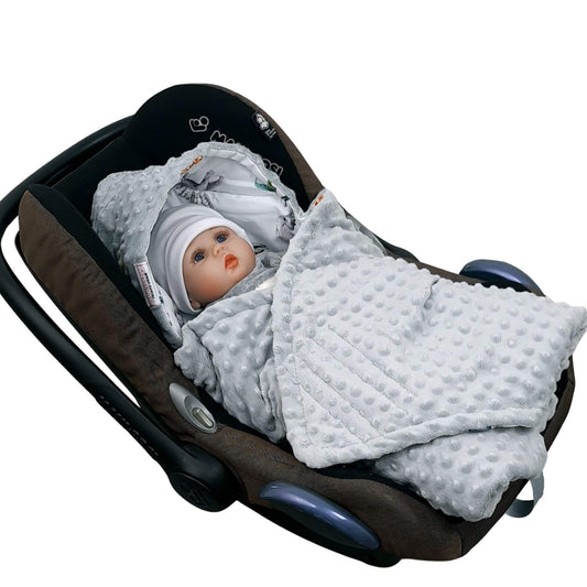 Newborn baby wrapped in Evcushy Safari Adventure car seat blanket with safari animal pattern and grey fleece