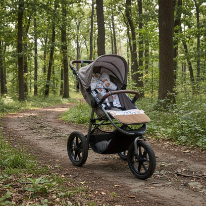 3-wheel stroller with playful forest animals pattern liner on a forest path surrounded by trees and greenery