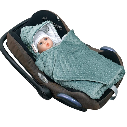 Newborn baby wrapped in Evcushy Tiny Roars car seat blanket with green dinosaur pattern and fleece