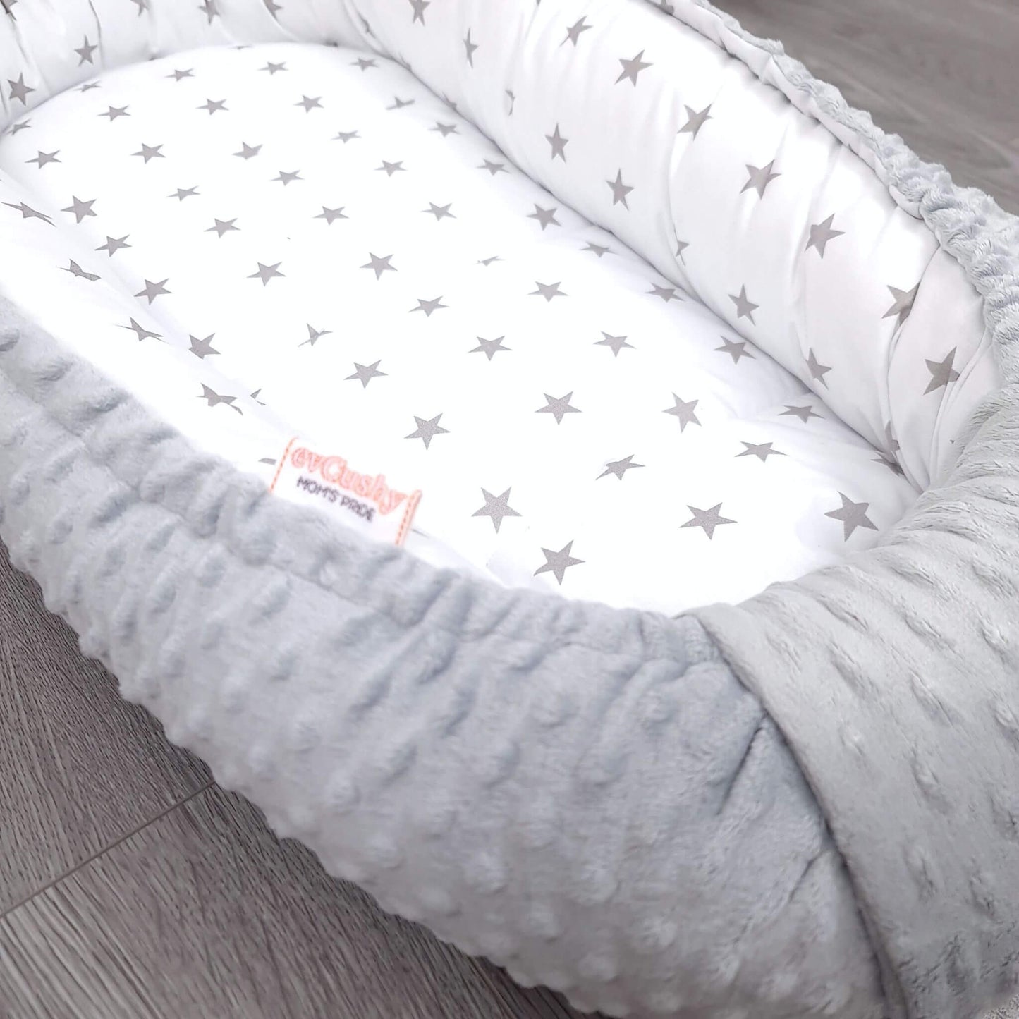 Close-up of plush grey minky fabric baby nest with white cotton grey star pattern – soft breathable newborn bedding by Evcushy
