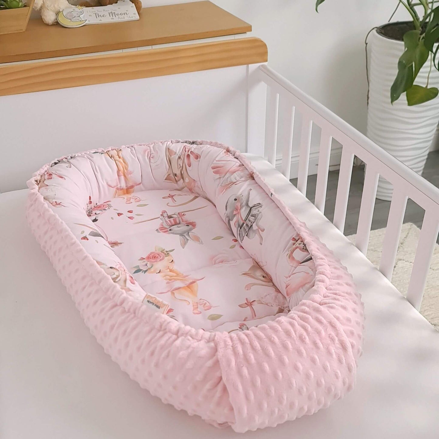 pink baby nest for sleep and lounge with bunnies kittens ballerinas and swans designed in Ireland