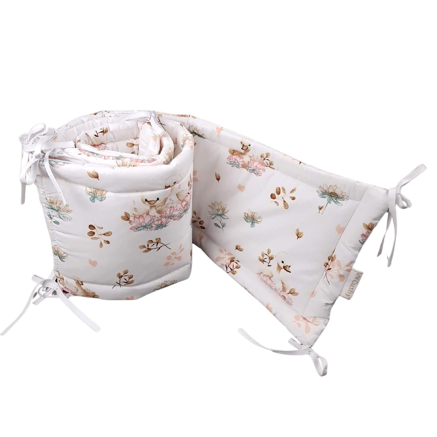 A baby crib cot bumper featuring elegant swans and delicate floral design made from breathable cotton in neutral colours
