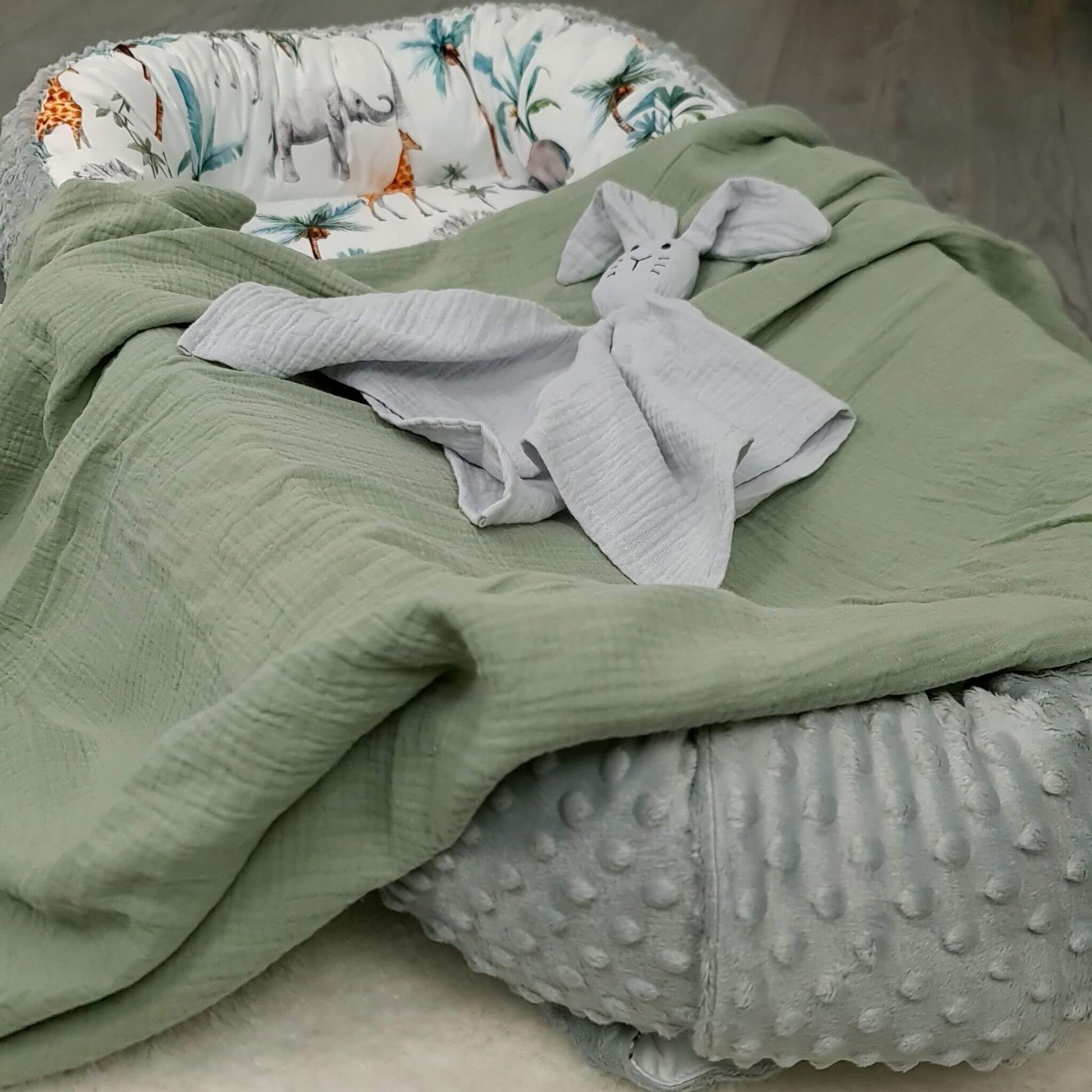 Close-up of safari pattern toddler nest with palm leaves, elephants and giraffes.