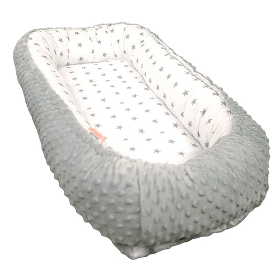 Baby nest with gray textured exterior and white interior with star pattern on a white background